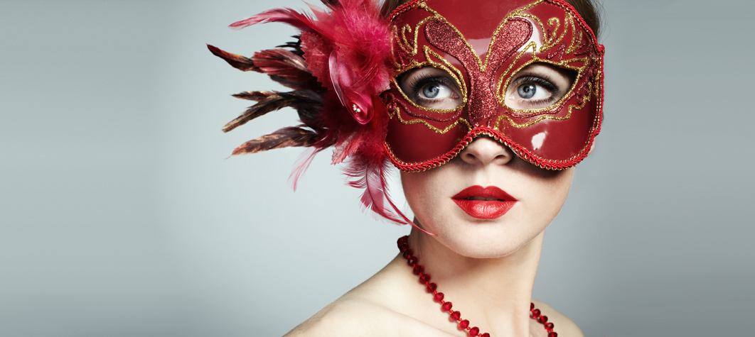 Woman looking sideways behind red masquerage mask